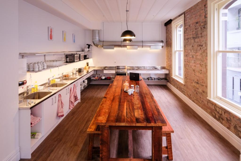 a large kitchen with a wooden table in the middle at Haka House Auckland K'Road in Auckland