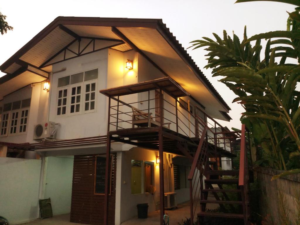 a house with a staircase in front of it at P.L.P Guesthouse - Mae Hong Son in Mae Hong Son