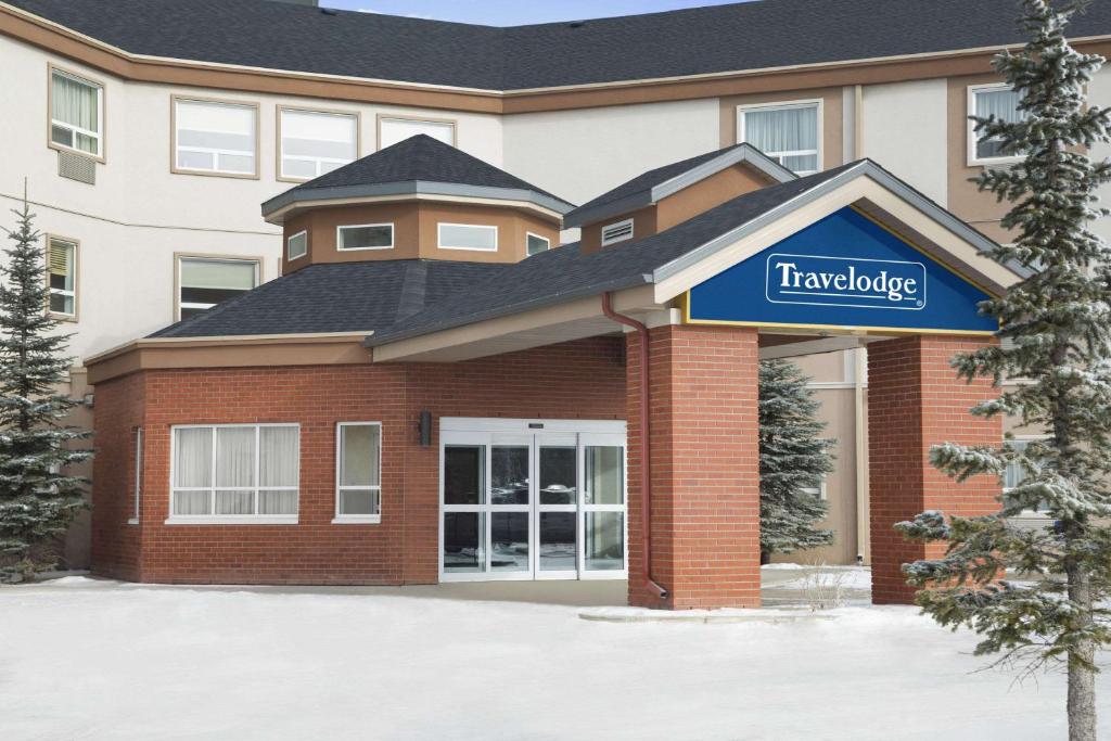 un edificio con una señal delante de él en Travelodge by Wyndham Strathmore, en Strathmore