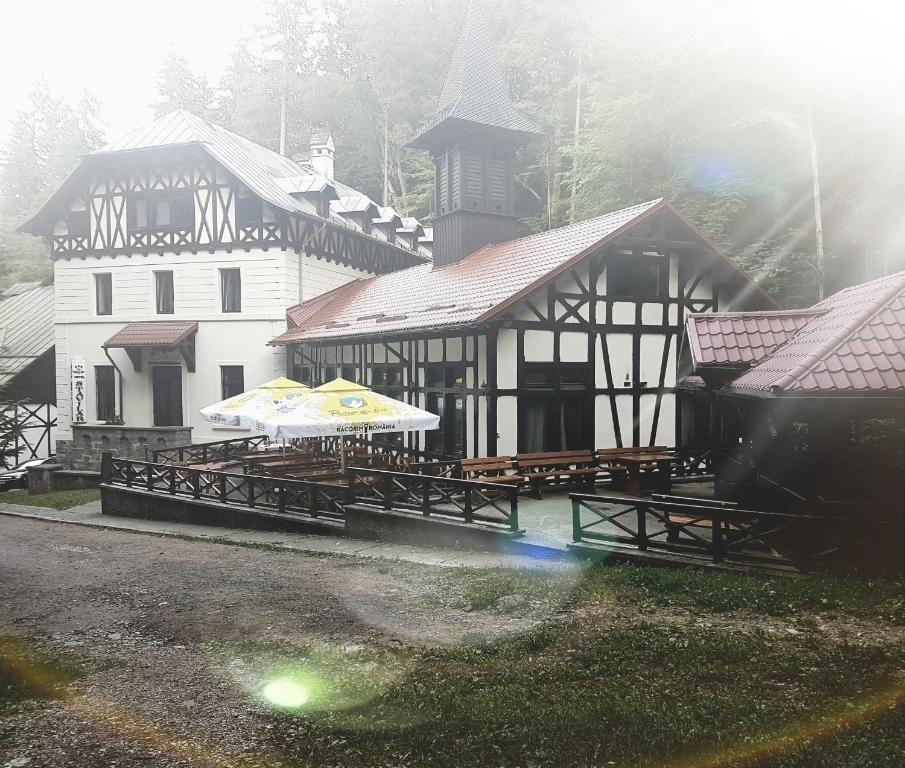 a building with tables and umbrellas in front of it at Hotel Stavilar in Sinaia