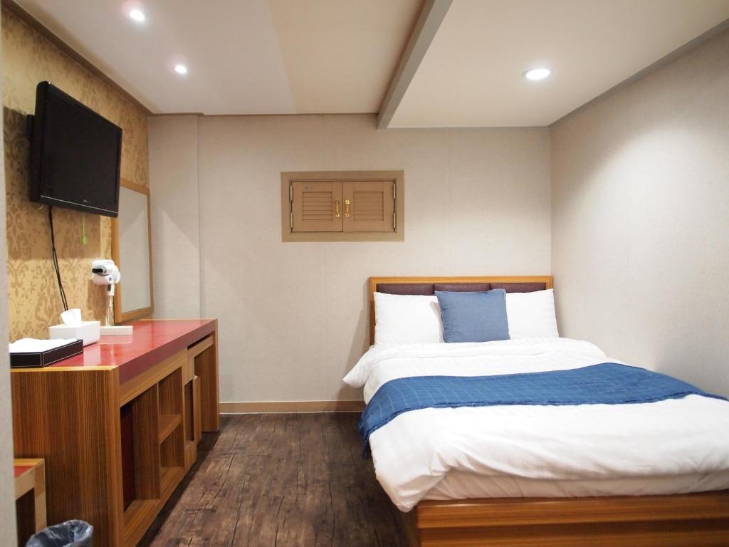 a hotel room with a bed and a television at Hostel J Stay in Seoul