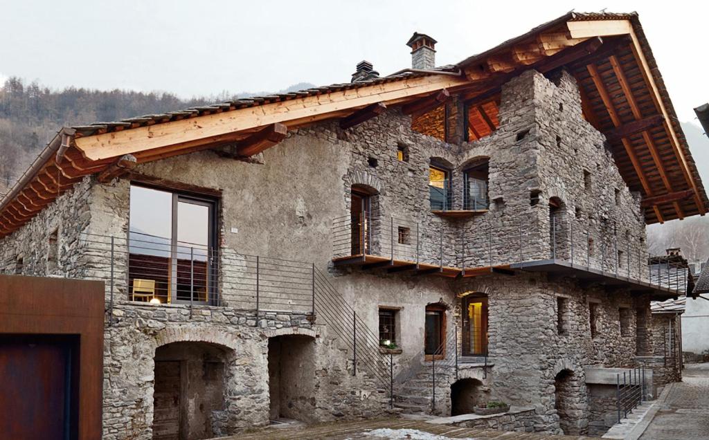 an old stone house with a wooden roof at Le Coffret in Saint Marcel