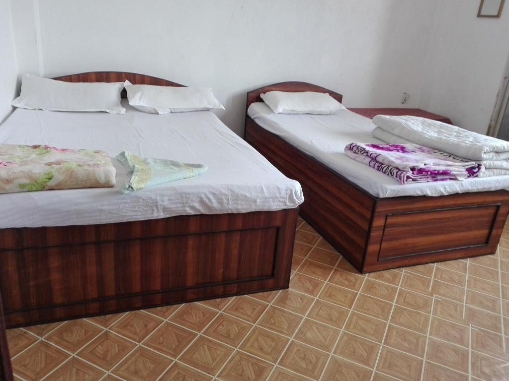 dos camas sentadas una al lado de la otra en una habitación en kayastha restaurant & lodge, en Bandipur