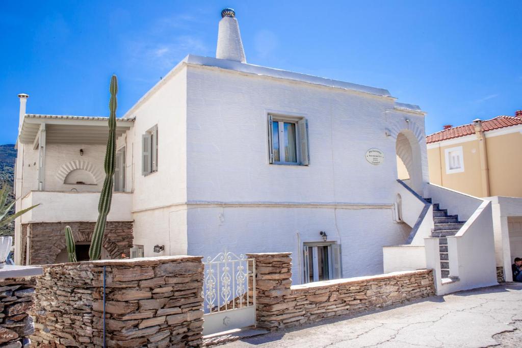 a white house with a cactus in front of it at Philoxenia Anemomilos in Andros