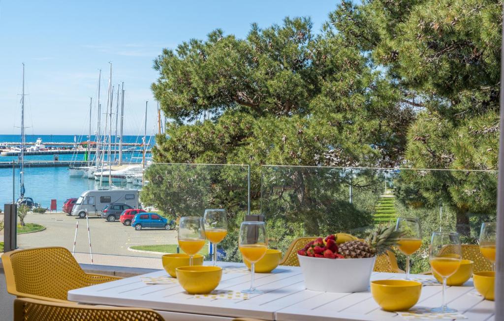 a table with wine glasses and a bowl of fruit at Luxury Apartments Novigrad in Novigrad Istria