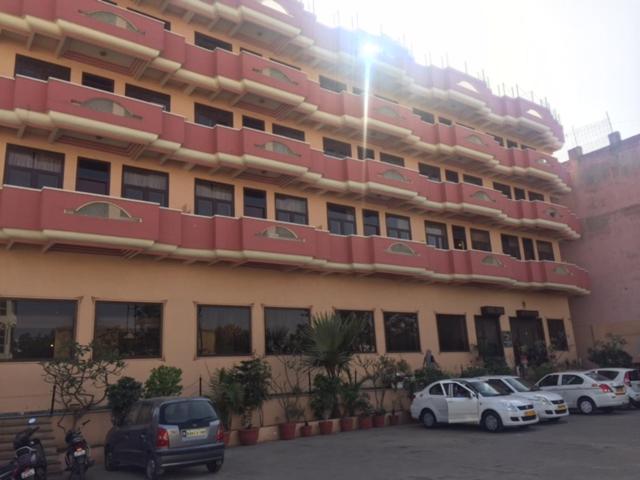 a large building with cars parked in front of it at Hotel Glitz Jaipur in Jaipur