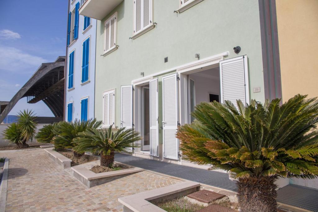 a building with palm trees in front of it at Rooms A due Passi dal Mare in Porto Recanati