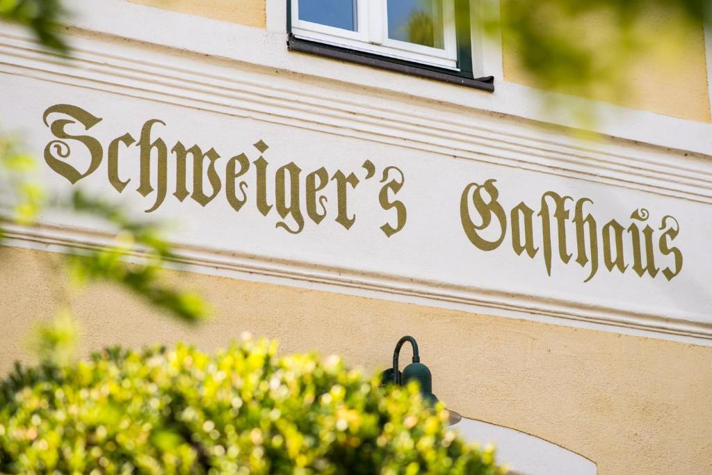 a sign on the side of a building with flowers at Schweiger's Landgasthof in Wartenberg