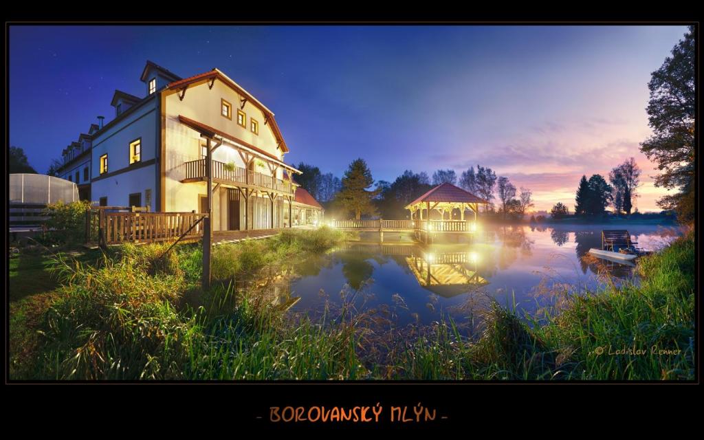 ein großes Gebäude neben einem See in der Nacht in der Unterkunft Borovansky mlyn in Borovany