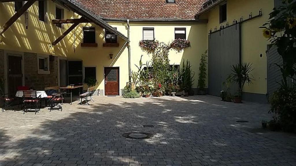 einen Innenhof eines Hauses mit einem Tisch und Stühlen in der Unterkunft Ferienhof Seeber in Weikersheim
