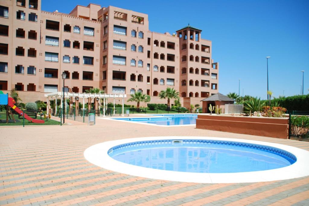 a swimming pool in front of a large building at Playa Verde by HOMA in Punta del Caimán