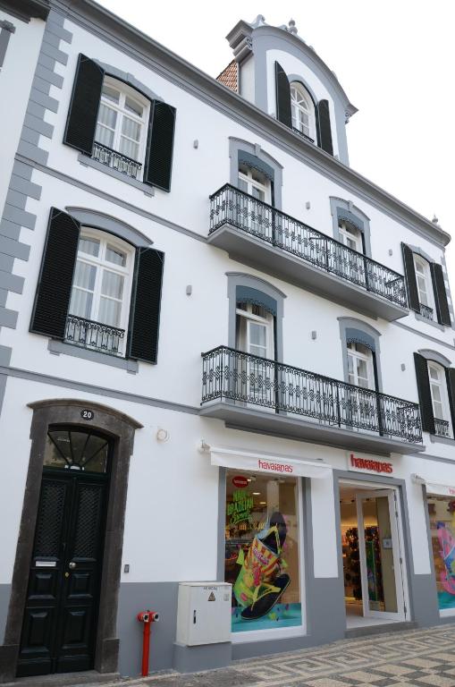 un edificio blanco con ventanas y balcones negros en Edificio Charles 103 en Funchal