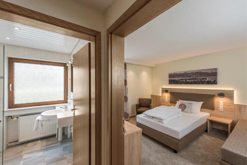 een kleine slaapkamer met een bed en een wastafel bij Hotel Bären in Rottweil