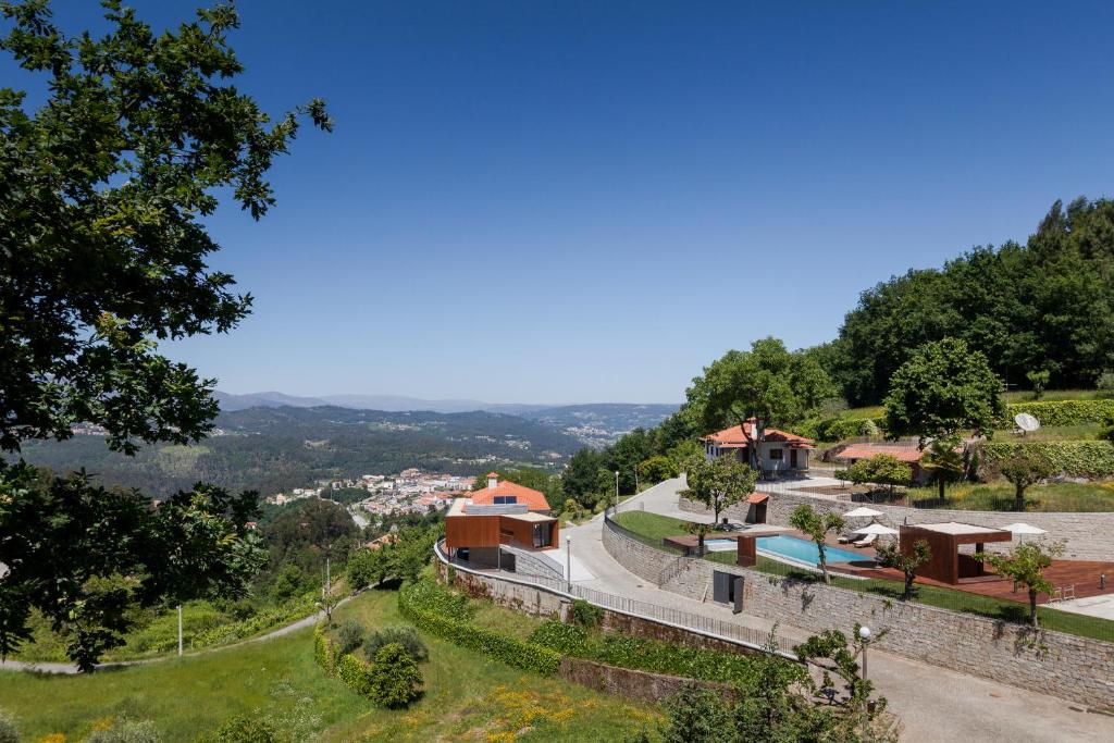 a house on the side of a hill with a road at Quinta do Fontelo in Vouzela