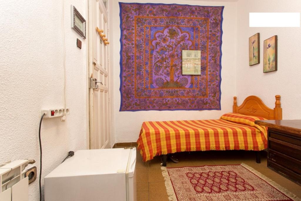 マドリードにあるResidencia de estudiantes DENVERのベッドとラグ付きの小さな部屋です。