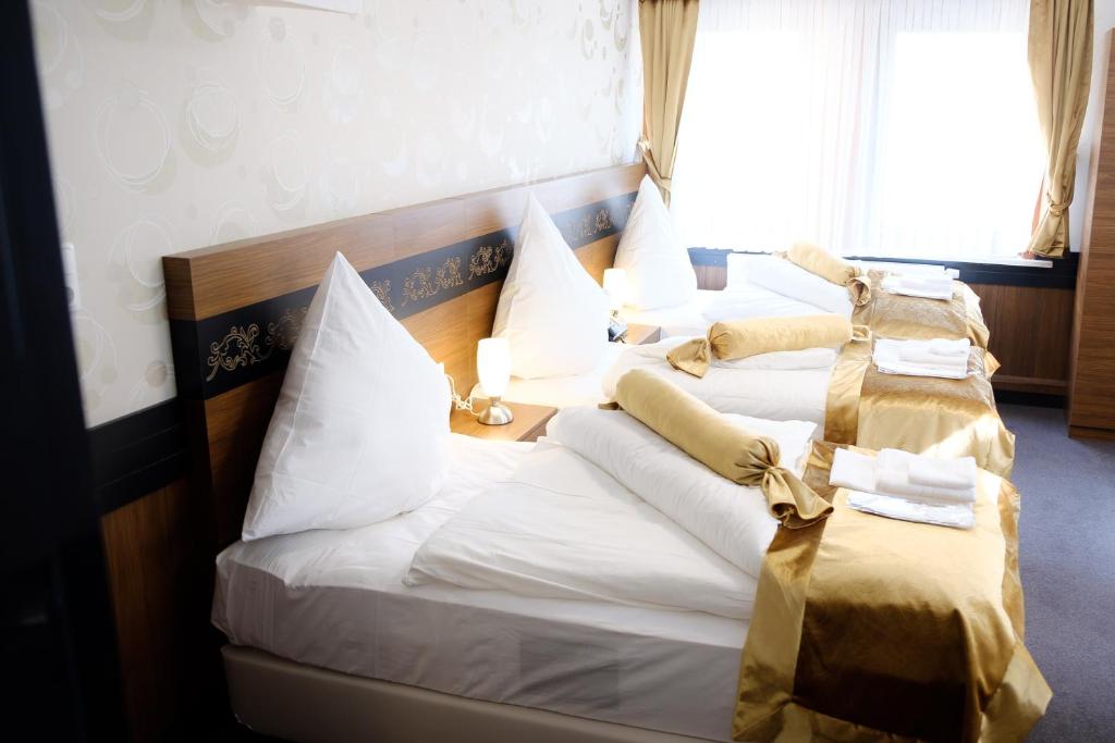 two beds in a hotel room with towels on them at Hotel im Anker in Hannoversch Münden