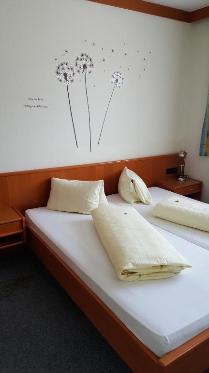 a bedroom with a bed with dandelions on the wall at Gastehaus Melcher in Villach
