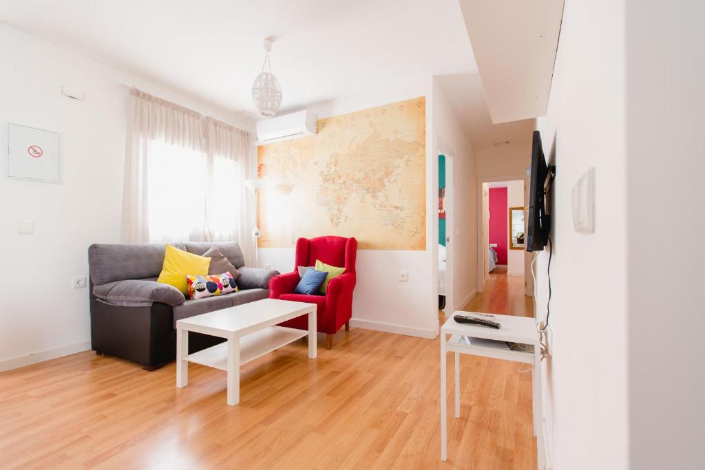 a living room with a couch and a red chair at Atico Centro Historico in Cádiz