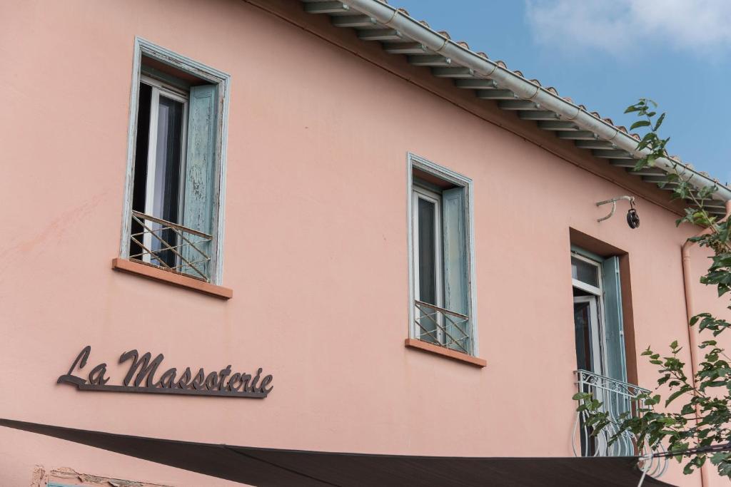 um edifício cor-de-rosa com três janelas. em La Massoterie gîte 1 em Théza