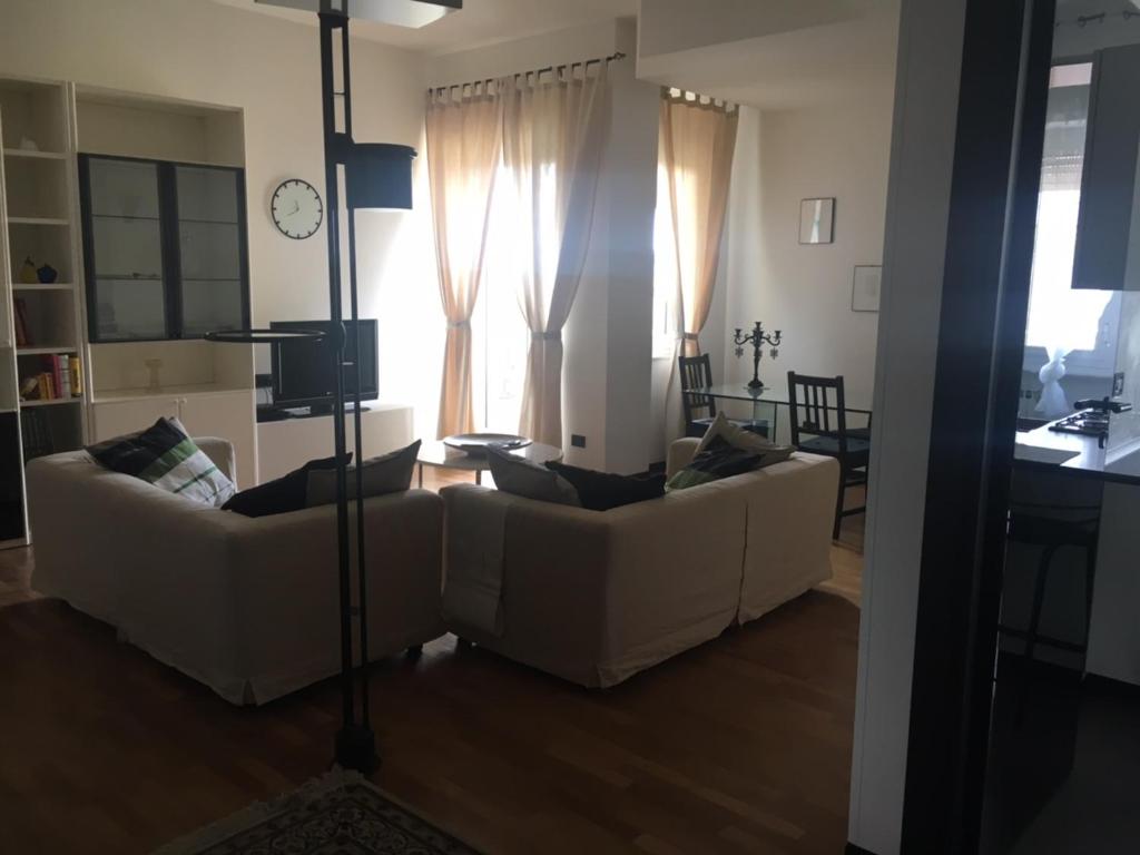 un soggiorno con 2 divani bianchi e un orologio di Our Home a La Spezia