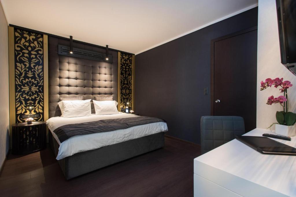 sypialnia z dużym łóżkiem z dużym zagłówkiem w obiekcie Egnatia Palace Hotel & Spa w Salonikach