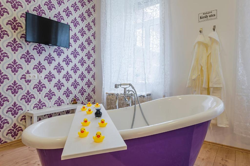 ein Badezimmer mit einer Badewanne mit Enten auf einem Tablett in der Unterkunft Elegant Coziness in Budapest