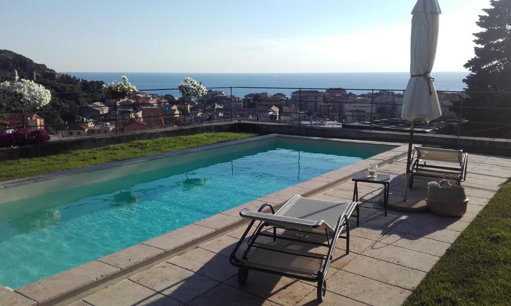 uma piscina com duas cadeiras e um guarda-sol em il corbezzolo - Suite em Levanto