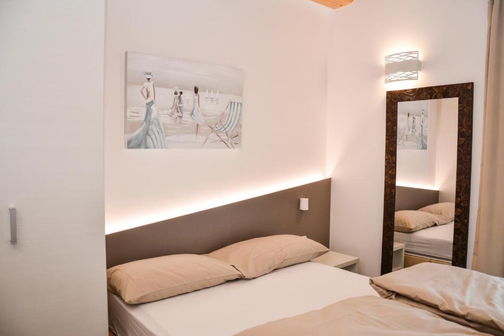 a bedroom with two beds and a mirror at Theresia in Riva del Garda