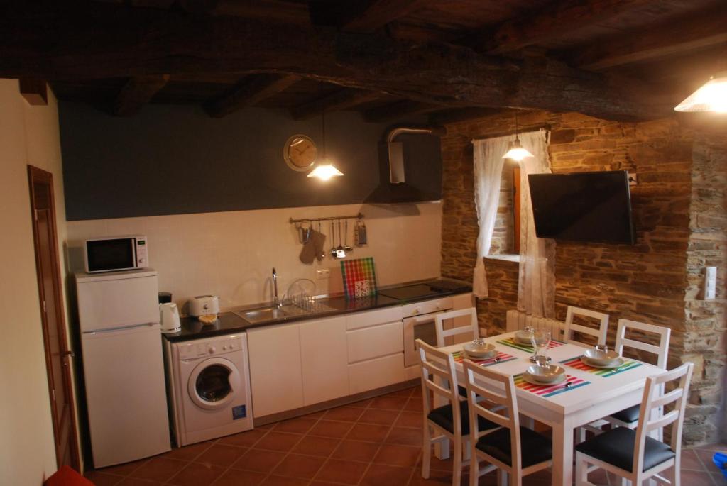 Una cocina y un comedor con mesa y sillas. en Isabel Artemis ES, en San Tirso de Abres