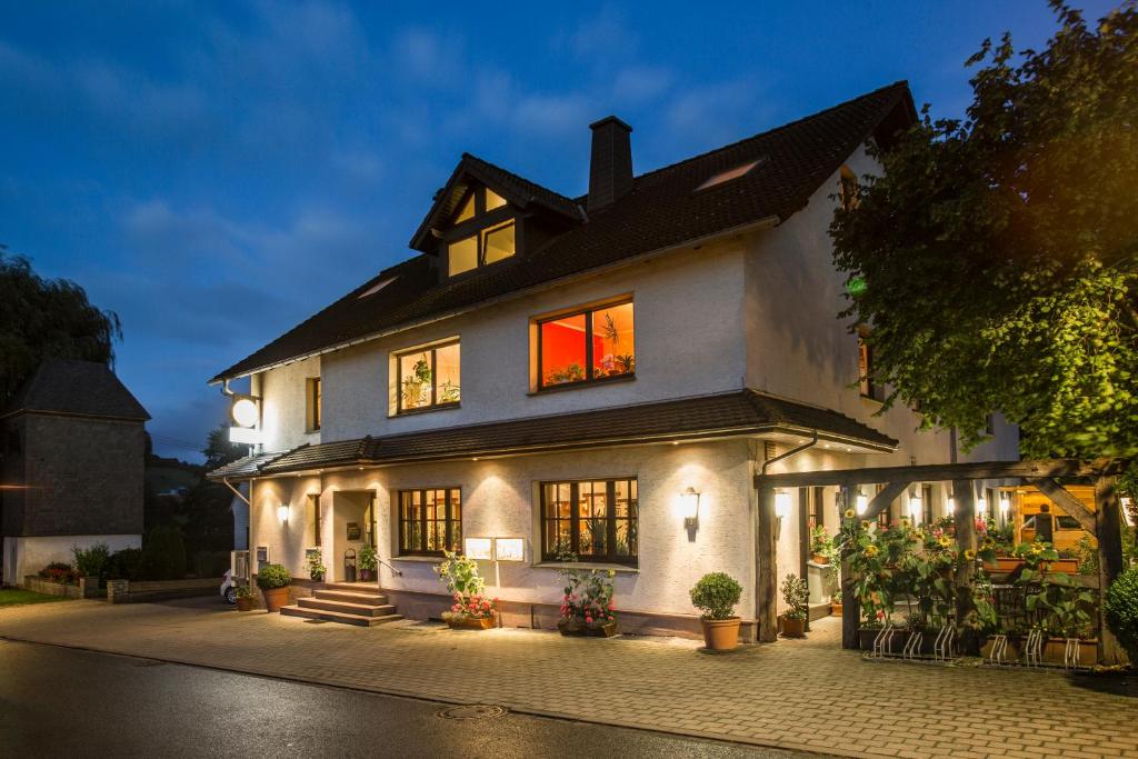 una gran casa blanca con sus luces encendidas en Gasthof im Almetal, en Büren