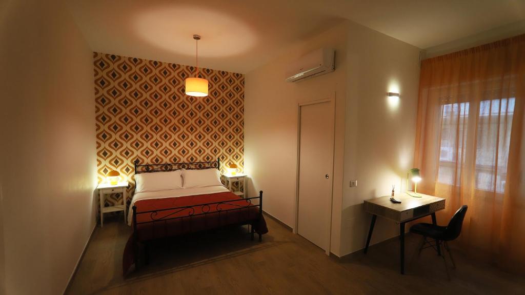 ナポリにある1970 ルームズのベッドルーム1室(ベッド1台、テーブル、窓付)