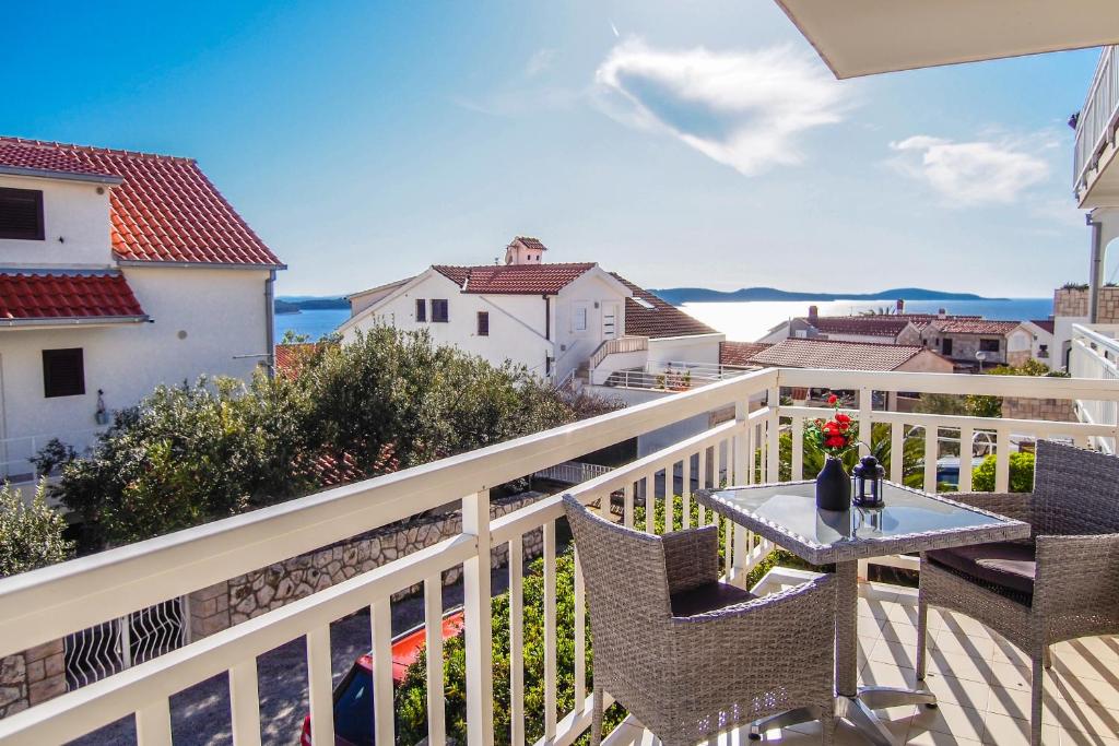 een balkon met een tafel en stoelen op een witte leuning bij The perfect stay in Hvar