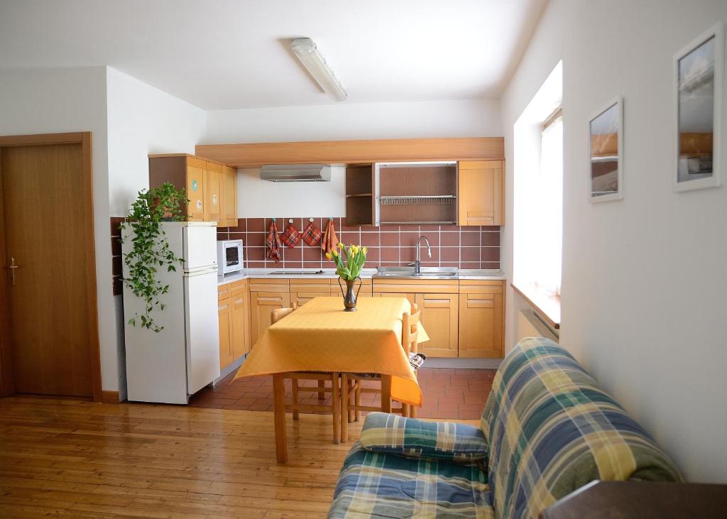 una cucina con tavolo e divano di Casa vacanze Dos de Loré - Relax a due passi da Tovel a Tuenno