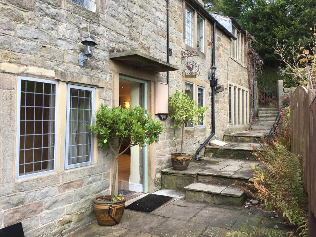 a stone house with stairs leading to a door at Rock View in Froggatt