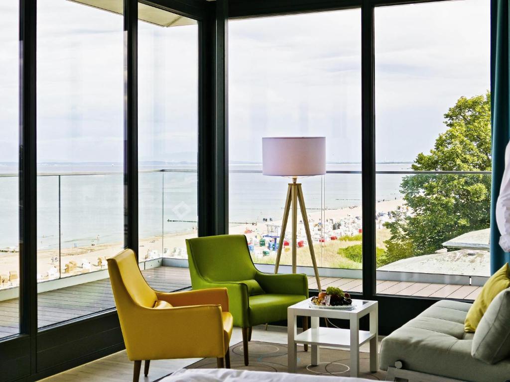 ein Wohnzimmer mit Blick auf den Strand in der Unterkunft SEETELHOTEL Kaiserstrand Beachhotel in Bansin