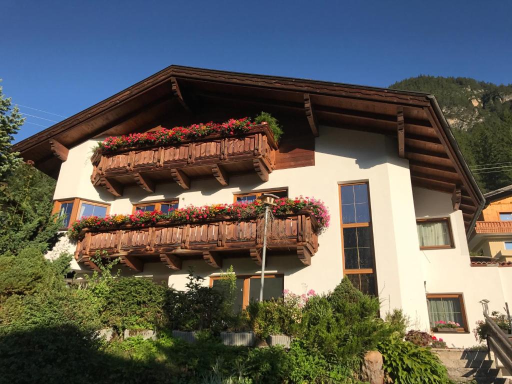 ein Haus mit Blumenkästen auf dem Balkon in der Unterkunft Ferienwohnung Bergler in Trins