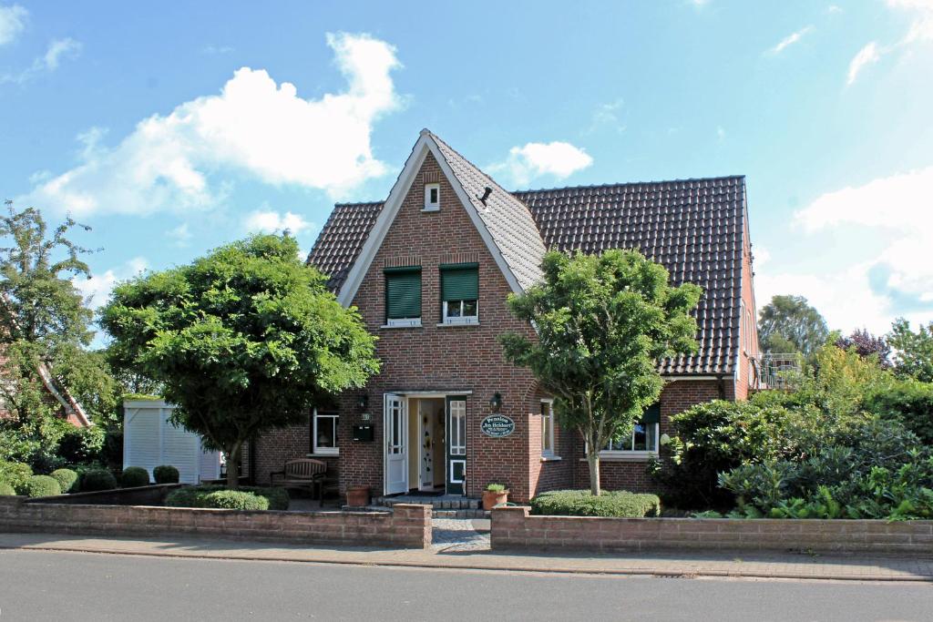 een rood bakstenen huis met een boom bij Pension im Heidort in Oyten