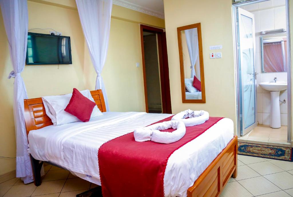 een slaapkamer met een bed met handdoeken erop bij Decasa Hotel in Nairobi