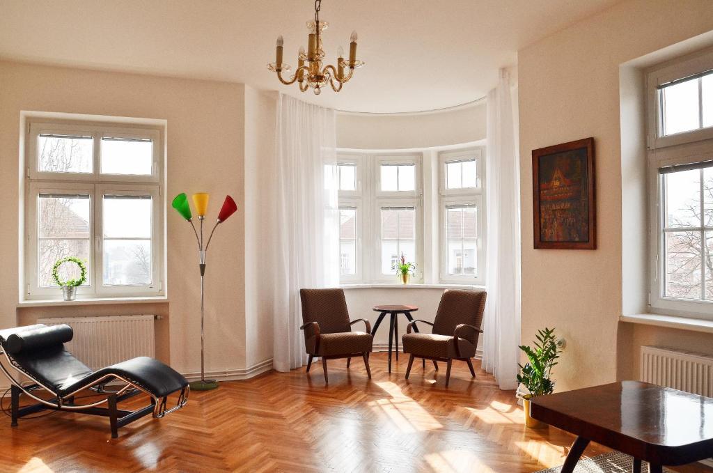 a living room with a table and chairs and windows at Apartmán u Masaryka in Hodonín