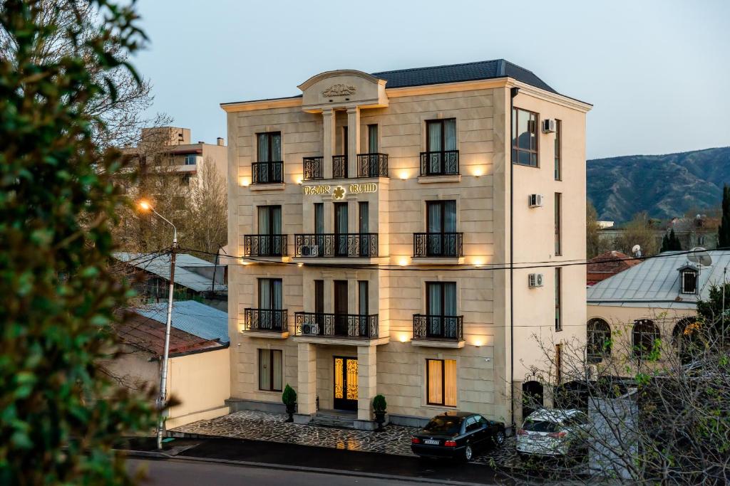 a large white building with a sign on it at Orchid Boutique Hotel in Tbilisi City