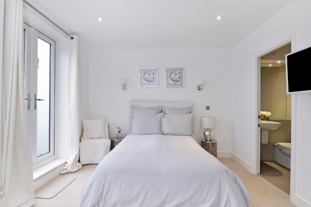 倫敦的住宿－Tower Bridge Lux-Townhouse，白色的卧室设有白色的床和窗户。
