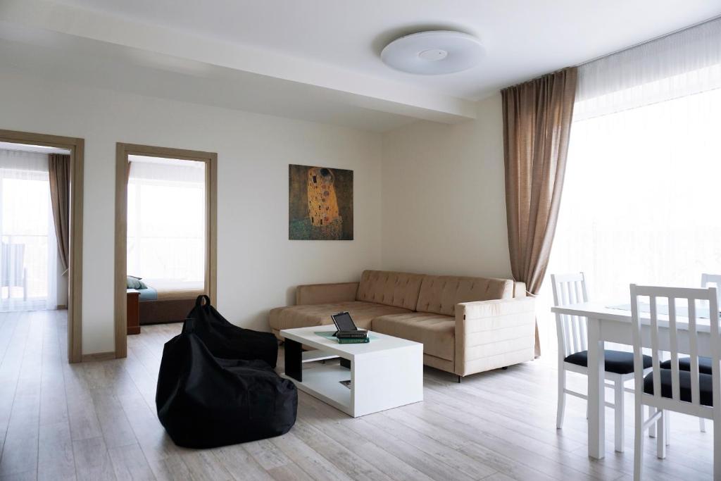 een woonkamer met een bank en een tafel bij Ąžuolo apartamentai in Birštonas