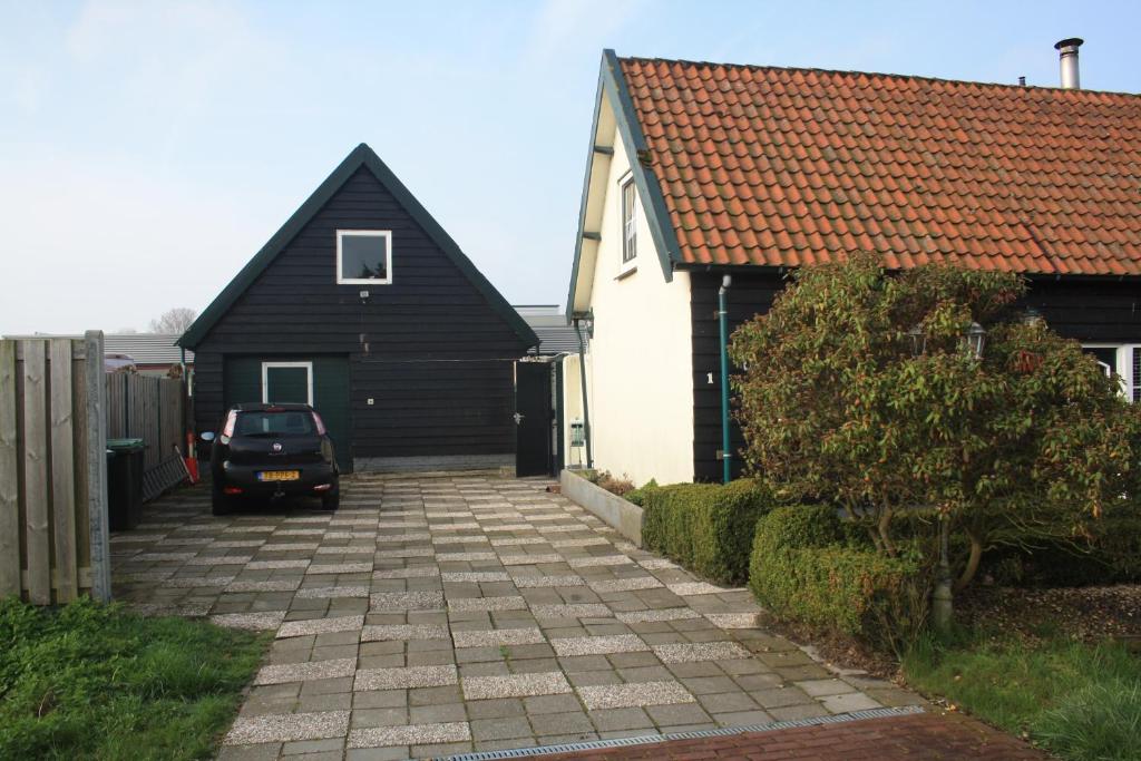 una casa y un coche aparcados frente a una entrada en Tuusje, en Vrouwenpolder