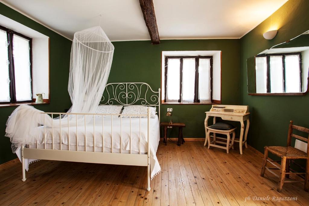 um quarto com paredes verdes e uma cama de dossel em La Corte di Alzo em Pella