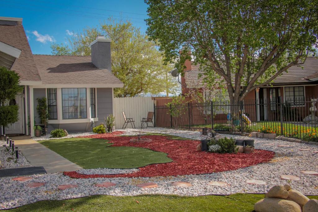 a yard with a garden in front of a house at Private Room in a 4 Bedroom House in Palmdale in Palmdale