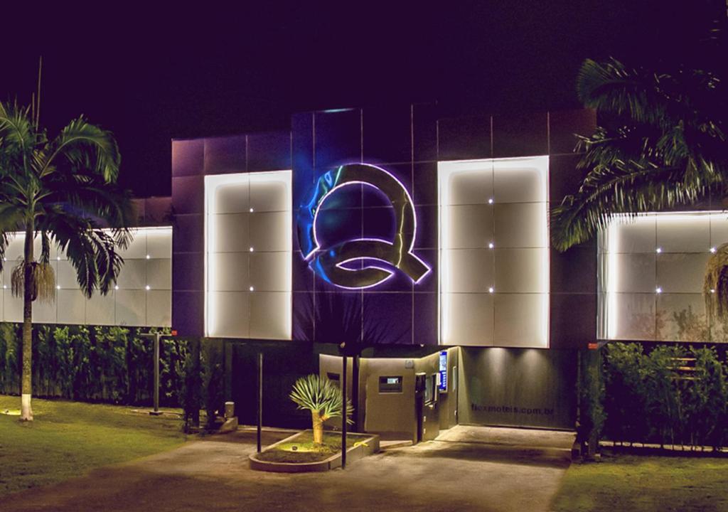 a building with a neon sign in front of it at Motel Quo in São Paulo