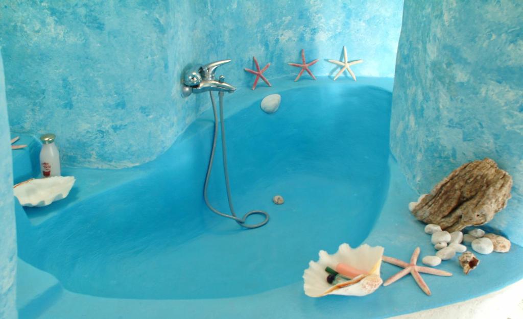 a blue bathroom with a shower in the ocean at Amelia Beachfront Villa in Korissia