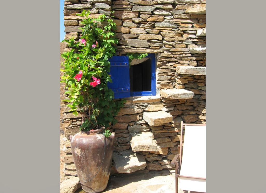 a stone wall with a window and a vase with flowers at Amelia Beachfront Villa in Korissia