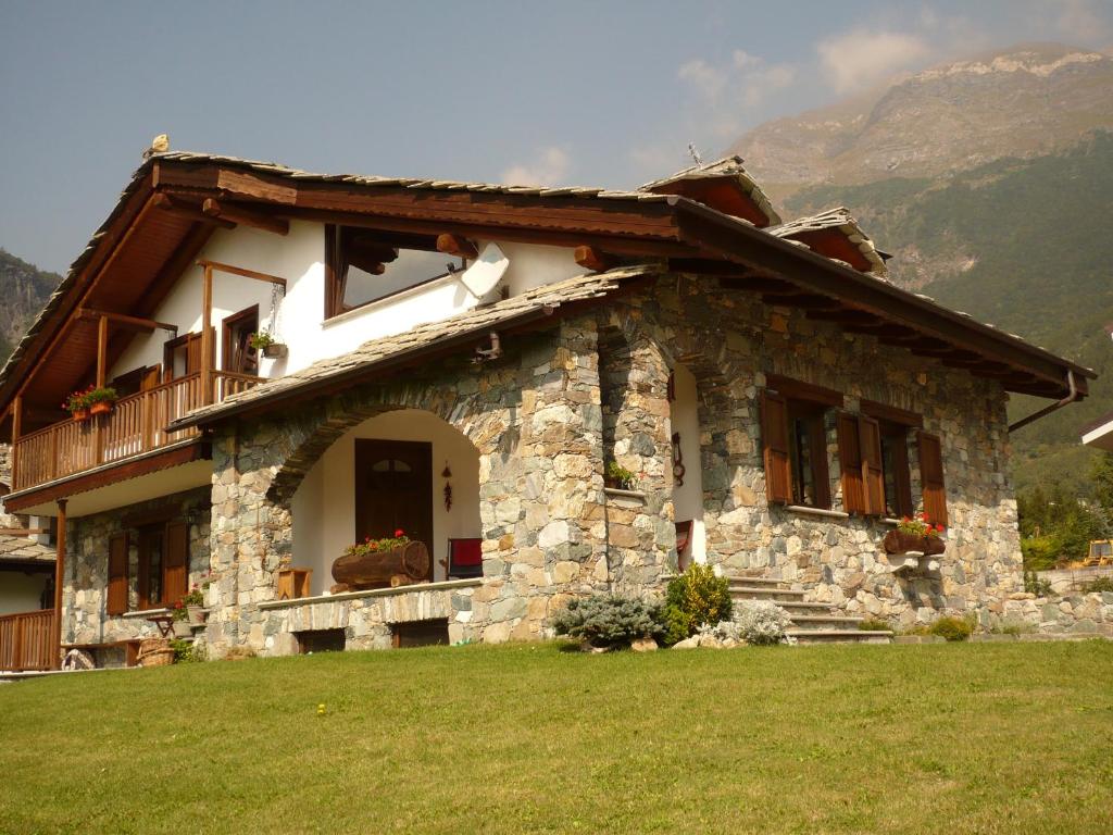 a stone house with a porch and a balcony at strada antica in Novalesa