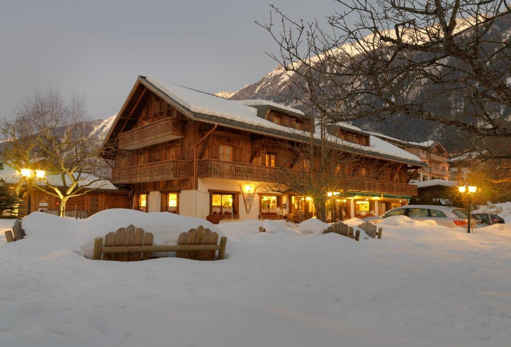a lodge with snow in front of a building at Auberge du Manoir in Chamonix